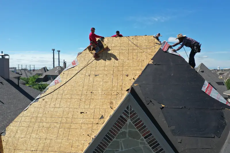 Crew installing decking on a steep roof