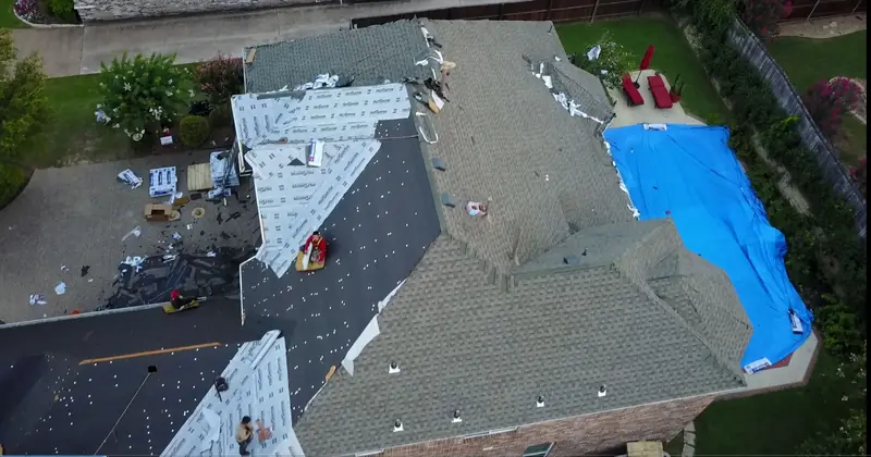 Roof repair in progress with a tarp protecting the open section