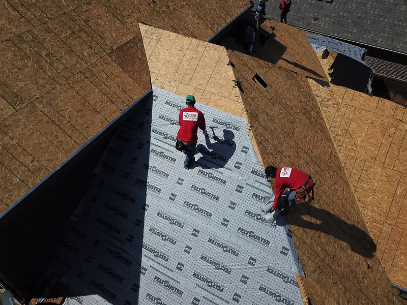 Kilker crew installing synthetic underlayment over new decking